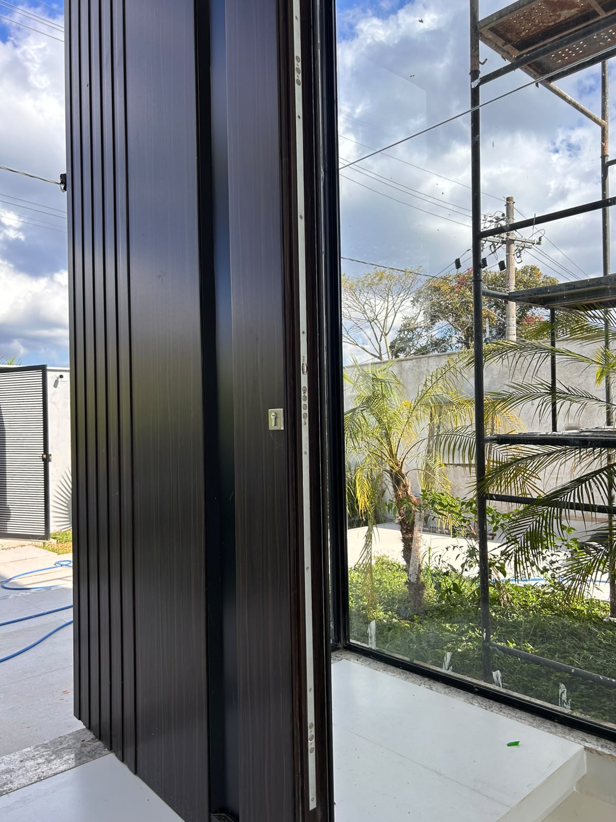 Detalhe do acabamento ripado em ACM da porta THE DOOR